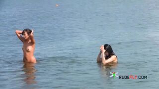 Nude beach girl sunbathes next to her man outdoors